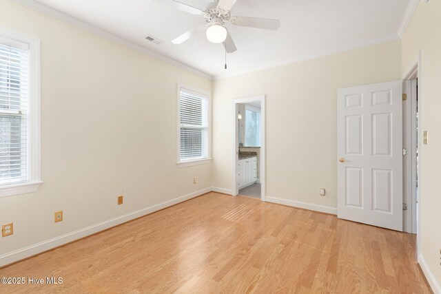 8630 Sound Dr Unit B2, Emerald Isle, NC 28594 - unfurnished bedroom with crown molding, multiple windows, light wood finished floors, ensuite bath, and a ceiling fan