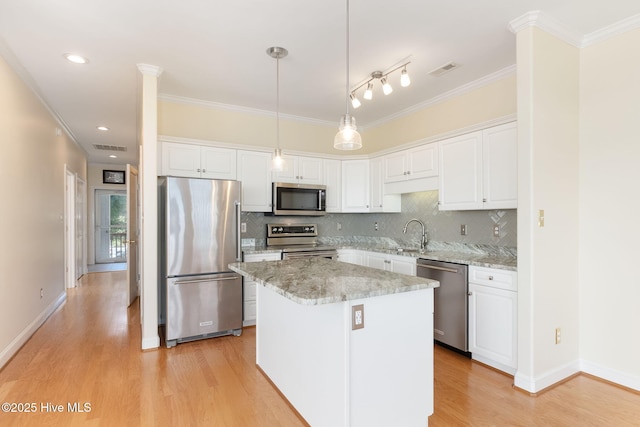 8630 Sound Dr Unit B2, Emerald Isle, NC 28594 - kitchen with stainless steel appliances, light wood finished floors, crown molding, white cabinets, and backsplash