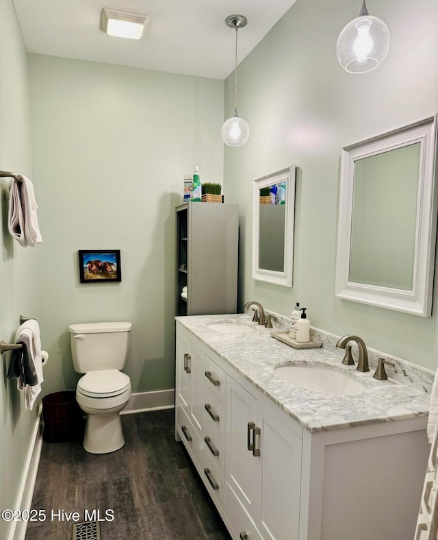 1044 Mill Creek Rd, Minnesott Beach, NC 28510 - full bath with wood finished floors, baseboards, double vanity, and toilet