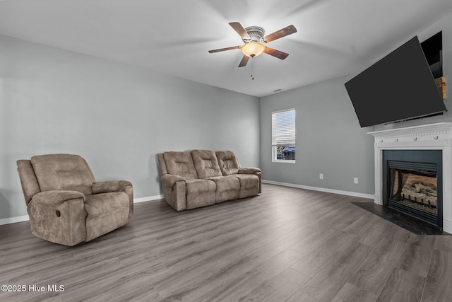 399 Highgrove Dr, Spring Lake, NC 28390 - living area with a ceiling fan, a fireplace with flush hearth, wood finished floors, and baseboards