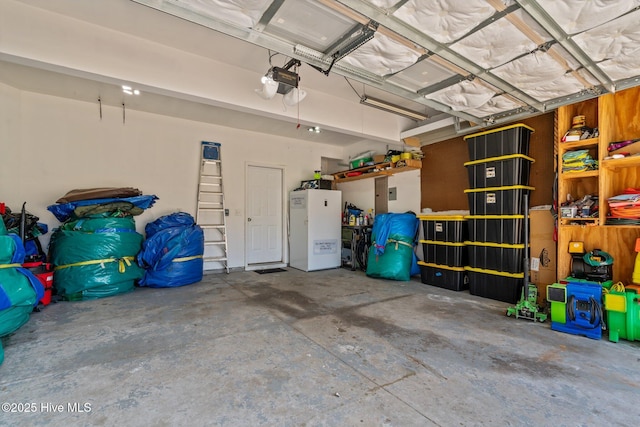 399 Highgrove Dr, Spring Lake, NC 28390 - garage featuring a garage door opener and freestanding refrigerator