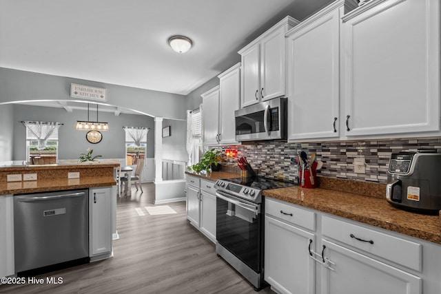 399 Highgrove Dr, Spring Lake, NC 28390 - kitchen with stainless steel appliances, ornate columns, arched walkways, white cabinets, and decorative backsplash