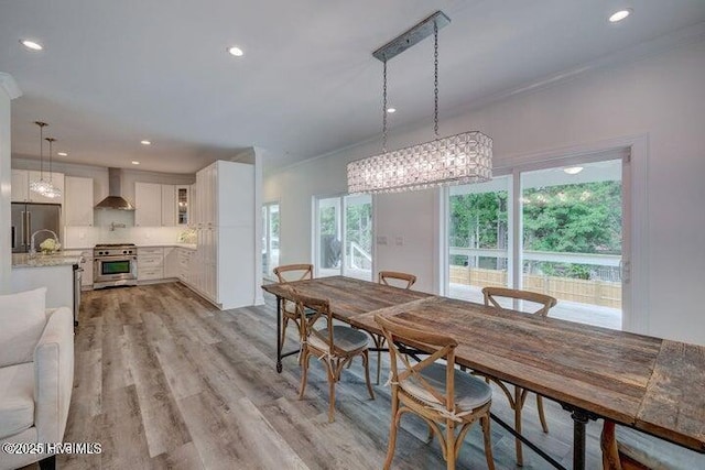 640 Avila Dr, Hampstead, NC 28443 - dining area with light wood-style flooring, recessed lighting, ornamental molding, and a chandelier