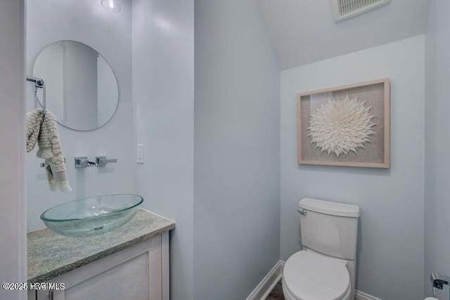 640 Avila Dr, Hampstead, NC 28443 - bathroom featuring toilet, vanity, lofted ceiling, and baseboards