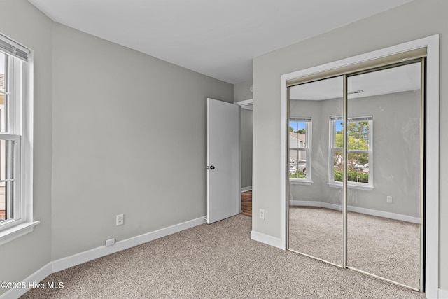 1703 41st St Apt B, Wilmington, NC 28403 - unfurnished bedroom with carpet floors, multiple windows, and a closet