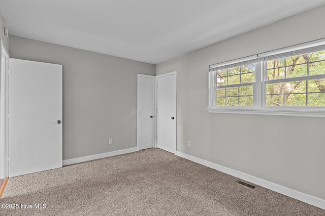 1703 41st St Apt B, Wilmington, NC 28403 - unfurnished bedroom featuring carpet floors and multiple windows