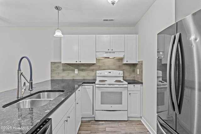 1703 41st St Apt B, Wilmington, NC 28403 - kitchen with appliances with stainless steel finishes, under cabinet range hood, white cabinetry, and dark stone countertops