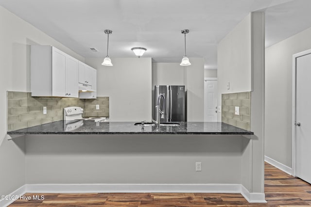 1703 41st St Apt B, Wilmington, NC 28403 - kitchen featuring white range with electric stovetop, a peninsula, freestanding refrigerator, dark stone countertops, and backsplash
