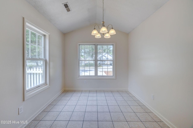 6901 Southern Exposure, Wilmington, NC 28412 - spare room featuring healthy amount of natural light, a chandelier, lofted ceiling, light tile patterned floors, and a textured ceiling