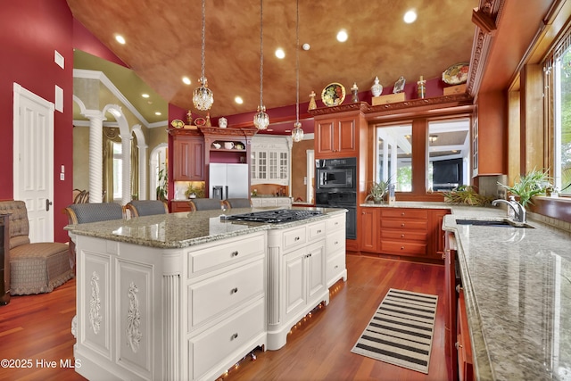 3530 Van Buren St SW, Supply, NC 28462 - kitchen with decorative columns, appliances with stainless steel finishes, a center island, hanging light fixtures, and dark wood-type flooring