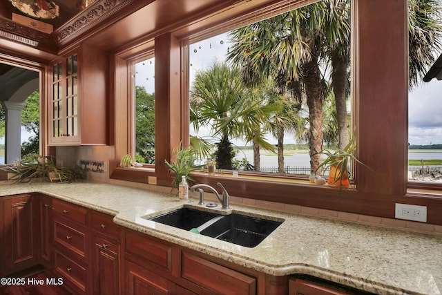 3530 Van Buren St SW, Supply, NC 28462 - kitchen with light stone counters, glass insert cabinets, healthy amount of natural light, and decorative backsplash
