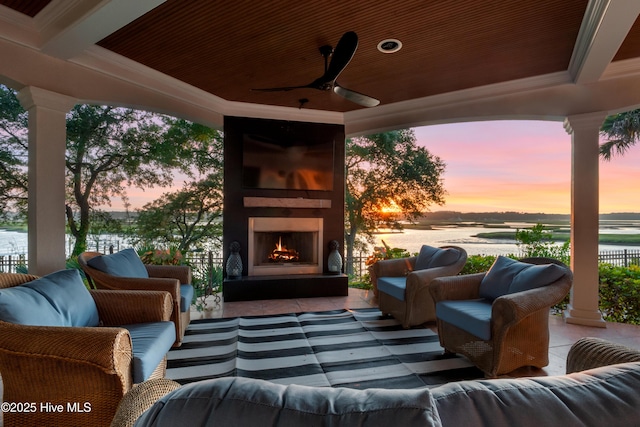 3530 Van Buren St SW, Supply, NC 28462 - patio terrace at dusk with an outdoor living space with a fireplace, a patio area, a water view, and a ceiling fan
