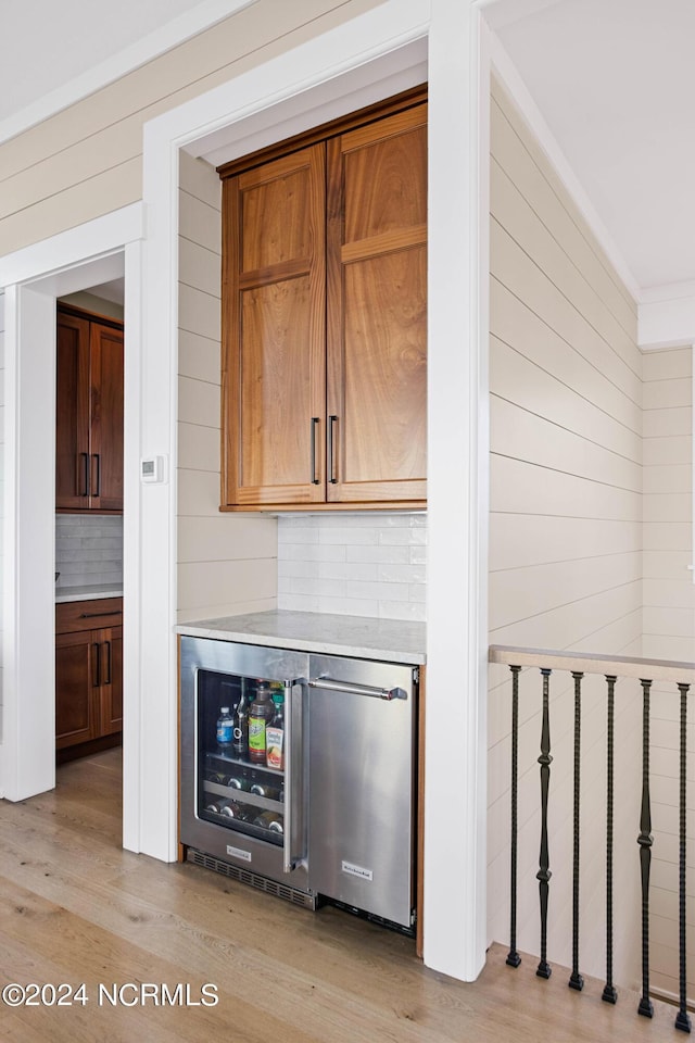 224 W Bald Head Wynd Wynd, Bald Head Island, NC 28461 - indoor dry bar with decorative backsplash, light wood-style flooring, wooden walls, and beverage cooler