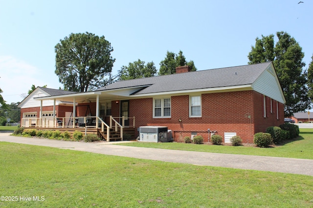 2945 US Highway 17, Williamston, NC 27892 - view of front of home featuring covered porch, brick siding, a front yard, and a chimney