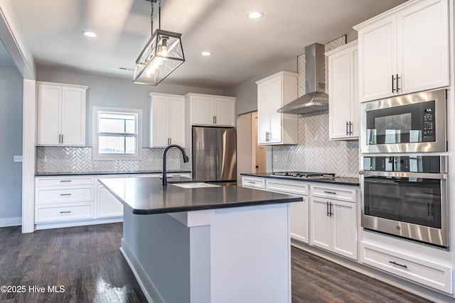 355 Shaw Rd, Cameron, NC 28326 - kitchen with appliances with stainless steel finishes, wall chimney exhaust hood, a sink, dark countertops, and dark wood-style floors
