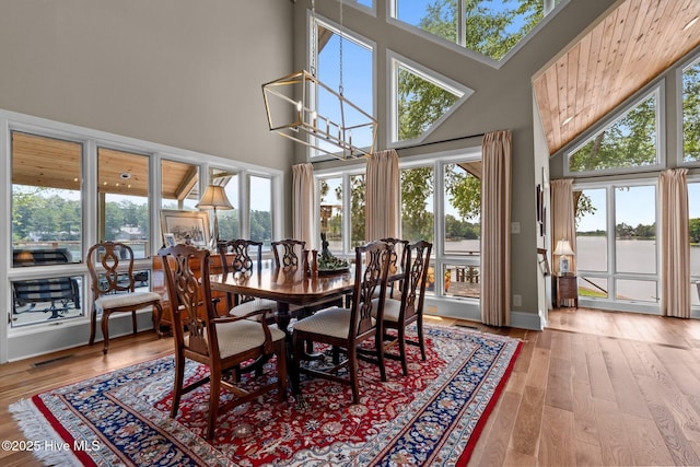 4 Lake Shore Ct, Pinehurst, NC 28374 - dining space with a high ceiling, wood finished floors, a water view, and a chandelier