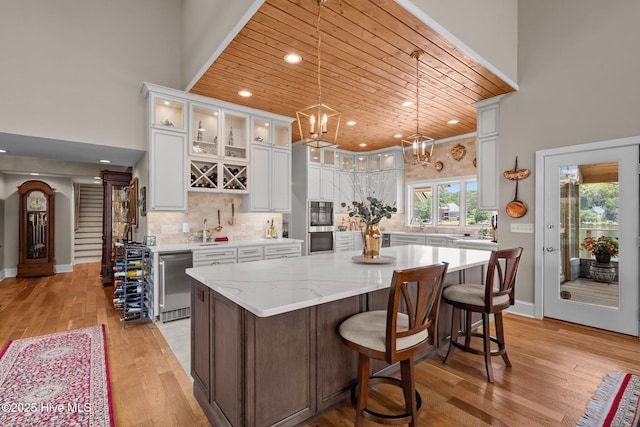 4 Lake Shore Ct, Pinehurst, NC 28374 - kitchen with light wood-type flooring, a kitchen island, white cabinets, glass insert cabinets, and recessed lighting