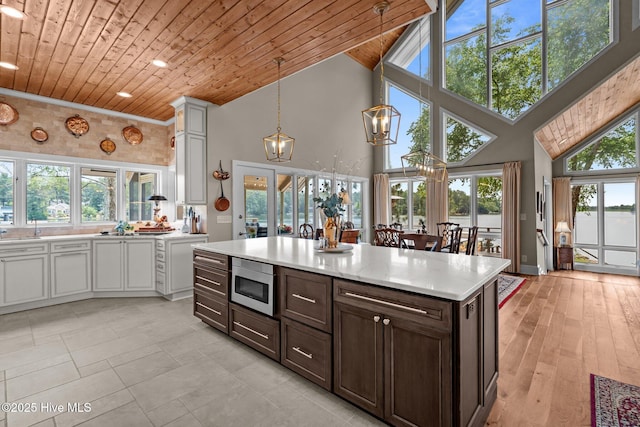4 Lake Shore Ct, Pinehurst, NC 28374 - kitchen with wood ceiling, stainless steel microwave, high vaulted ceiling, a chandelier, and light countertops