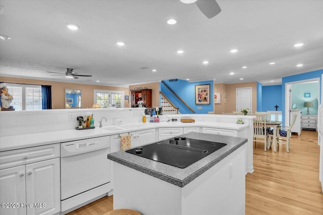 813 Cutter Ct, Kure Beach, NC 28449 - kitchen featuring dishwasher, black electric stovetop, ceiling fan, white cabinets, and a kitchen island