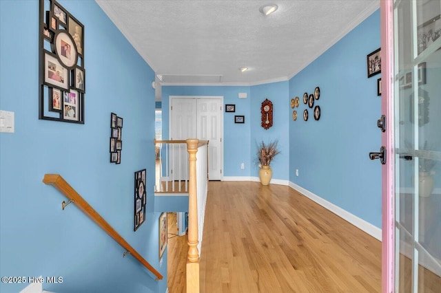 813 Cutter Ct, Kure Beach, NC 28449 - hall with an upstairs landing, wood finished floors, a textured ceiling, ornamental molding, and attic access