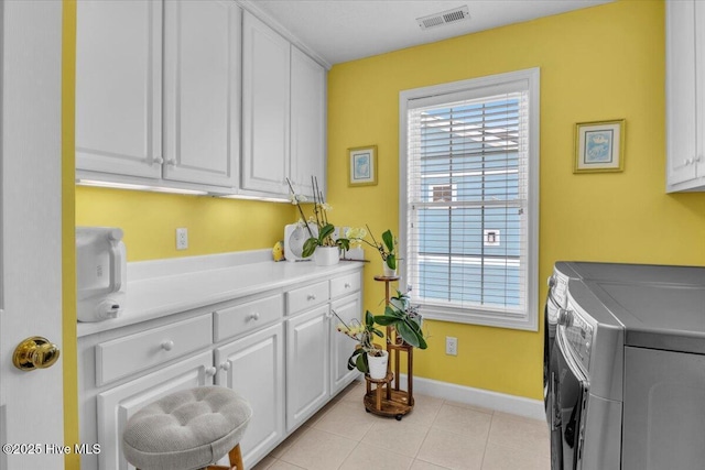813 Cutter Ct, Kure Beach, NC 28449 - laundry area featuring cabinet space, washing machine and dryer, and light tile patterned floors