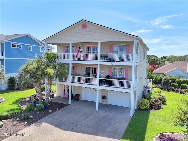 813 Cutter Ct, Kure Beach, NC 28449 - view of front of house featuring an attached garage, driveway, a front lawn, and a balcony