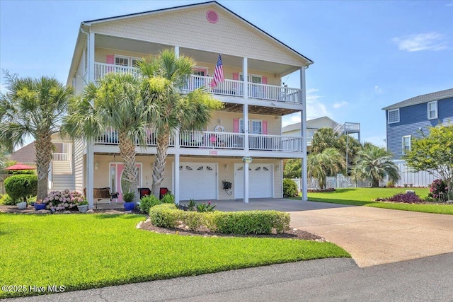 813 Cutter Ct, Kure Beach, NC 28449 - view of front facade featuring driveway, a garage, a balcony, and a front lawn