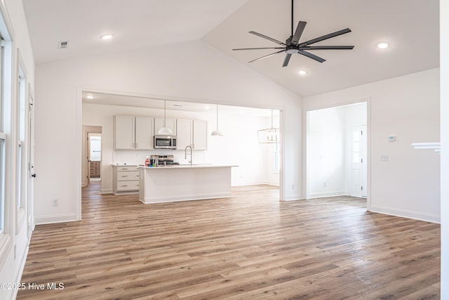 193 Jim S Rd, Cameron, NC 28326 - unfurnished living room with ceiling fan, light wood-style floors, high vaulted ceiling, recessed lighting, and baseboards