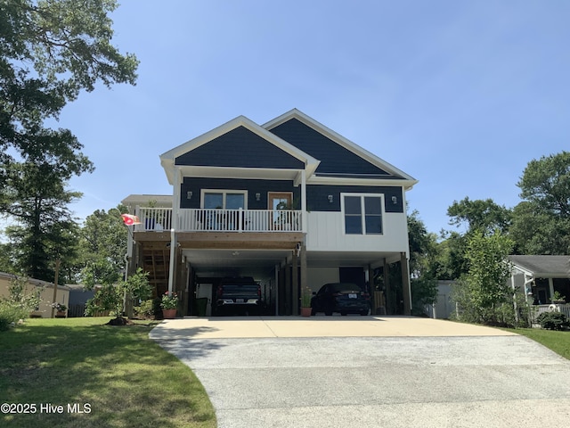 7605 E Yacht Dr NE, Oak Island, NC 28465 - view of front of property featuring a carport, concrete driveway, a front lawn, and a porch