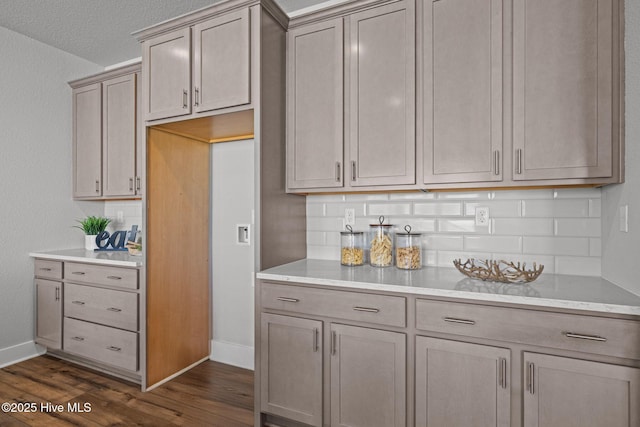 101 Claire Ct, Moyock, NC 27958 - kitchen featuring dark wood-type flooring, backsplash, baseboards, and light stone countertops