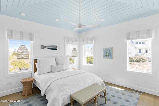11 Sandspur Trl, Bald Head Island, NC 28461 - bedroom with multiple windows, wood finished floors, and a ceiling fan