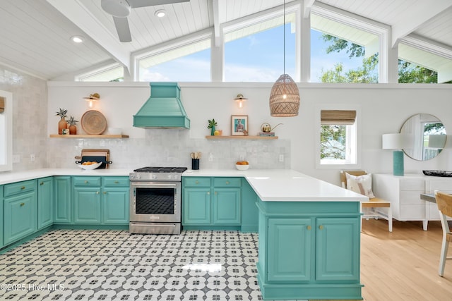 3343 Channelside Dr SW, Supply, NC 28462 - kitchen with stainless steel gas stove, open shelves, custom range hood, a peninsula, and plenty of natural light