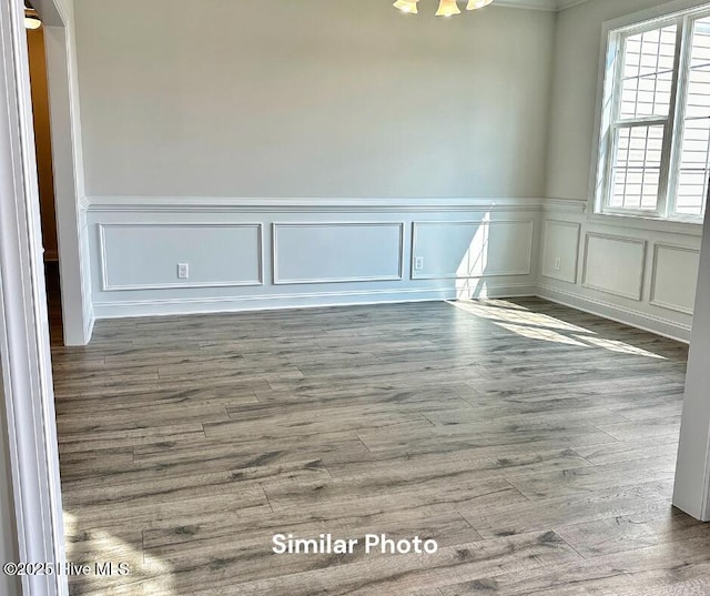 1822 Olde Towne Pointe Blvd, Jacksonville, NC 28546 - spare room with wainscoting, a decorative wall, a chandelier, and wood finished floors