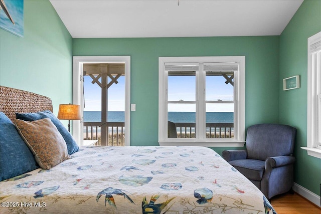 1033 Ocean Blvd W, Holden Beach, NC 28462 - bedroom featuring multiple windows, access to exterior, wood finished floors, and a water view