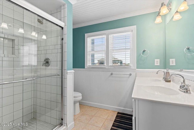 1033 Ocean Blvd W, Holden Beach, NC 28462 - bathroom featuring wainscoting, double vanity, tile patterned floors, a shower stall, and crown molding