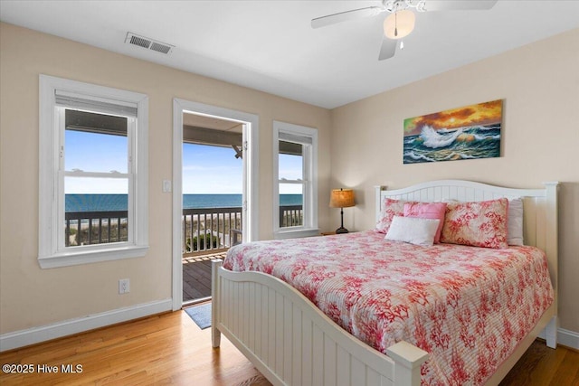 1033 Ocean Blvd W, Holden Beach, NC 28462 - bedroom featuring access to exterior, light wood-type flooring, a water view, and a ceiling fan