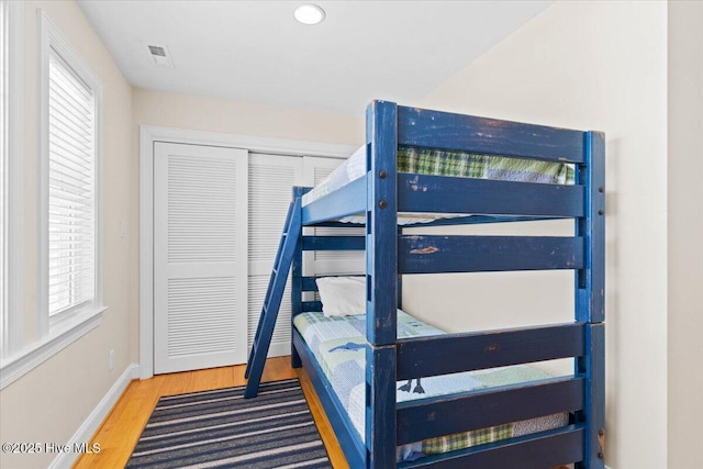 1033 Ocean Blvd W, Holden Beach, NC 28462 - bedroom with wood finished floors, multiple windows, and a closet