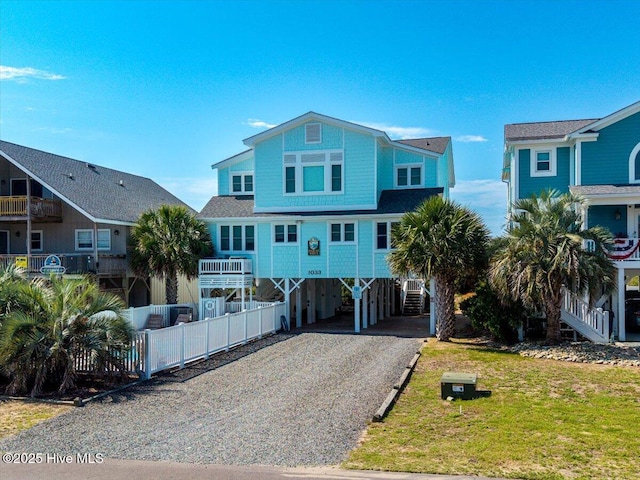 1033 Ocean Blvd W, Holden Beach, NC 28462 - raised beach house with a carport, driveway, and stairs