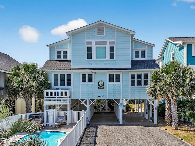1033 Ocean Blvd W, Holden Beach, NC 28462 - rear view of house featuring a carport, driveway, and roof with shingles