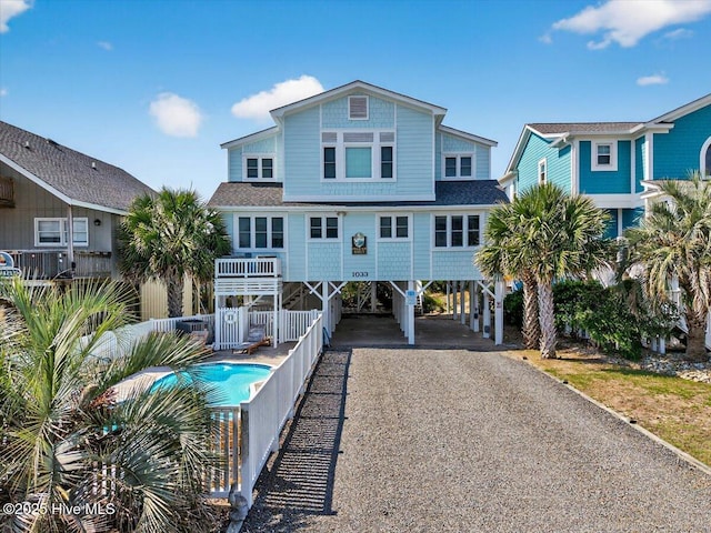 1033 Ocean Blvd W, Holden Beach, NC 28462 - view of front facade with a carport, driveway, and a shingled roof