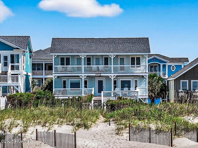 1033 Ocean Blvd W, Holden Beach, NC 28462 - raised beach house with a porch and a shingled roof