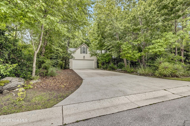 208 Bloomington Ln, Wilmington, NC 28411 - obstructed view of property with a garage, concrete driveway, and view of wooded area