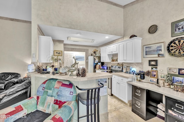 208 Bloomington Ln, Wilmington, NC 28411 - kitchen with stainless steel appliances, white cabinets, a breakfast bar area, a peninsula, and a high ceiling