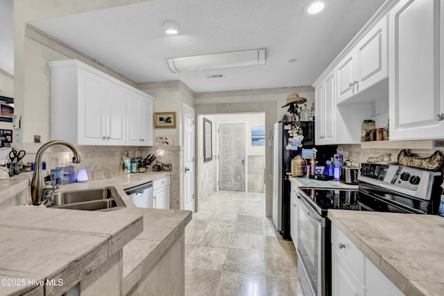 208 Bloomington Ln, Wilmington, NC 28411 - kitchen featuring stainless steel appliances, a sink, white cabinetry, decorative backsplash, and recessed lighting