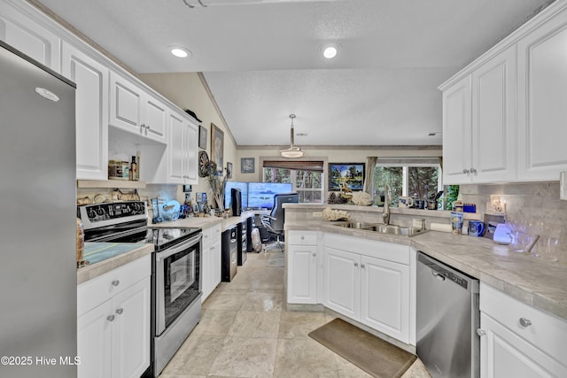 208 Bloomington Ln, Wilmington, NC 28411 - kitchen featuring appliances with stainless steel finishes, a sink, decorative backsplash, light countertops, and lofted ceiling