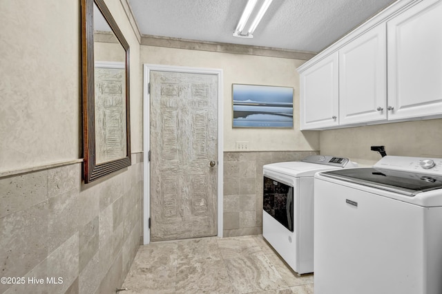 208 Bloomington Ln, Wilmington, NC 28411 - laundry room with cabinet space, washing machine and dryer, a textured ceiling, tile walls, and a wainscoted wall