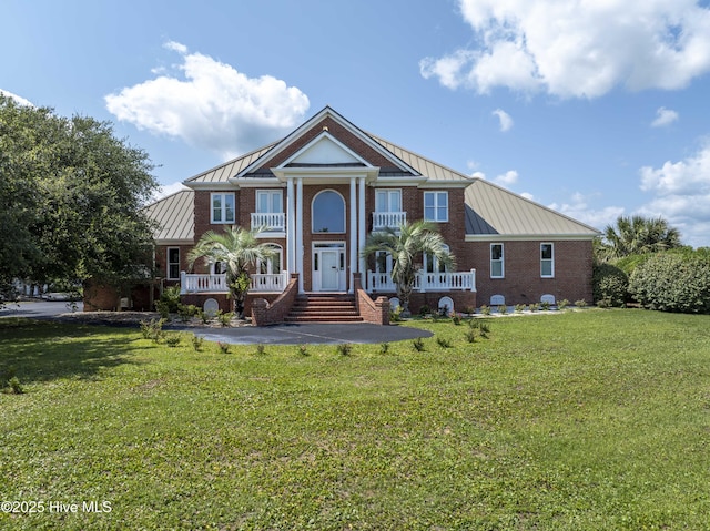 4 Hunter Heath Dr, North Topsail Beach, NC 28460 - neoclassical home featuring a standing seam roof, a metal roof, covered porch, and a front lawn
