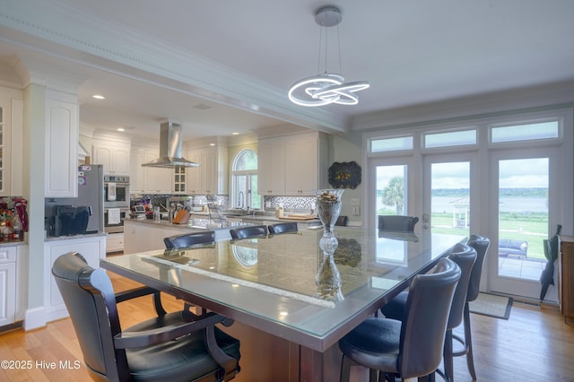 4 Hunter Heath Dr, North Topsail Beach, NC 28460 - kitchen with island exhaust hood, crown molding, a chandelier, backsplash, and a kitchen breakfast bar