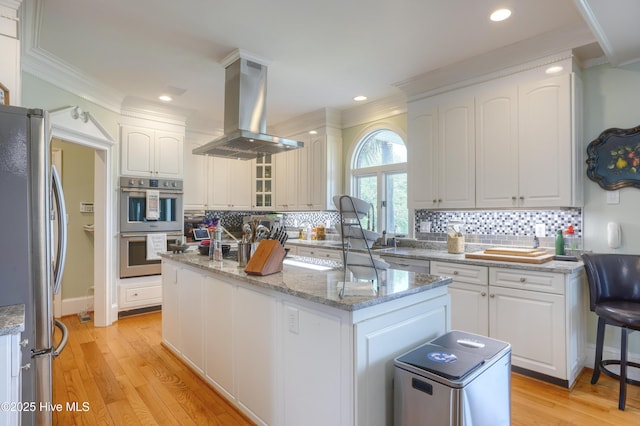 4 Hunter Heath Dr, North Topsail Beach, NC 28460 - kitchen featuring stainless steel appliances, island range hood, ornamental molding, a kitchen island, and white cabinetry