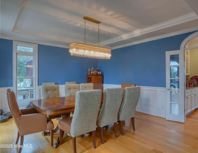 4 Hunter Heath Dr, North Topsail Beach, NC 28460 - dining room with light wood-style flooring, a chandelier, a wainscoted wall, crown molding, and a decorative wall